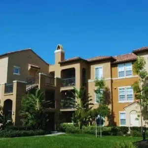 Three-story apartment building in Southern California with landscaped lawn, showing typical residential structure for parking compliance discussions.