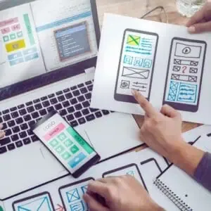 Team designing accessible website layouts with mobile and desktop wireframes for ADA compliance